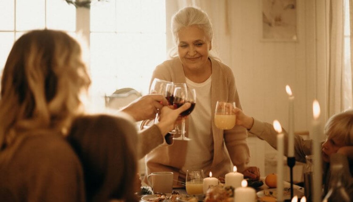 woman-on-gray-cardigan-standing-near-table-doing-cheers-3171199
